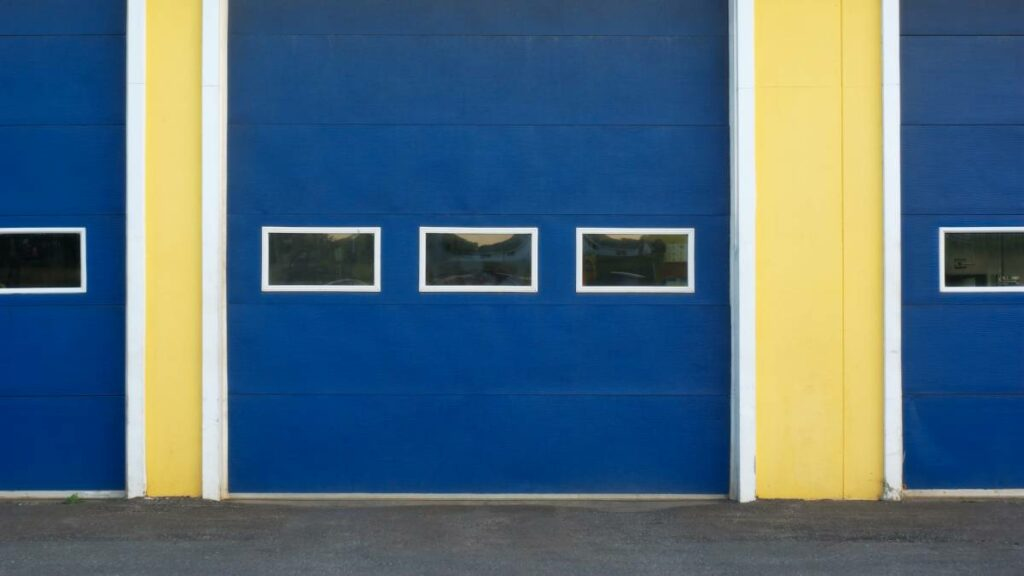 a bold blue garage door in harmony with yellow walls
