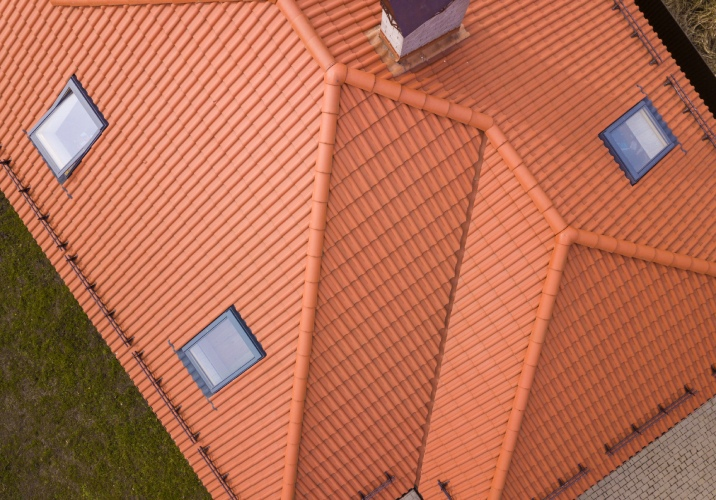 Aerial view of an orange tiled single storey house with 3 skylights and a cimney