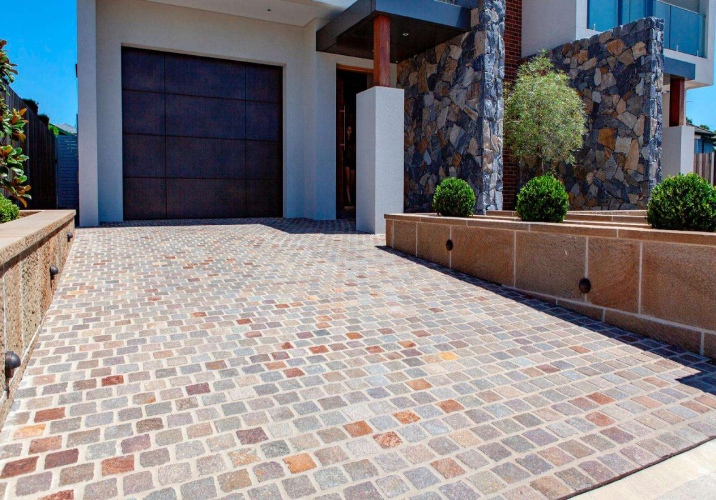 Pebble-stone driveway of a two-storey rendered house.