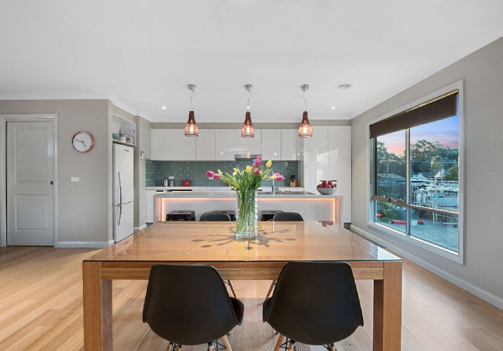 A kitchen and dining room with three decorative pendant lights