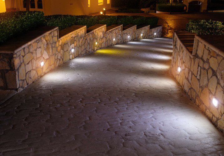 A steep driveway with lights in the wall on both sides