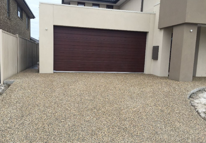 A driveway made from beige exposed concrete