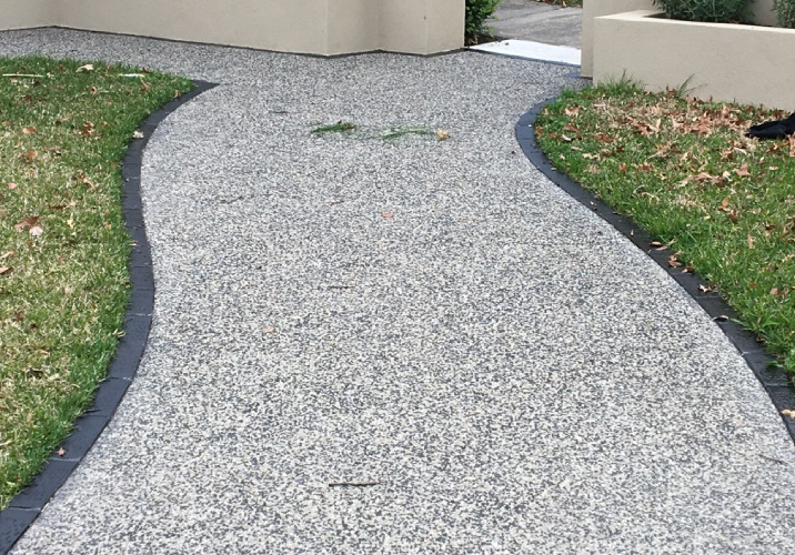 A garden path made from grey exposed concrete