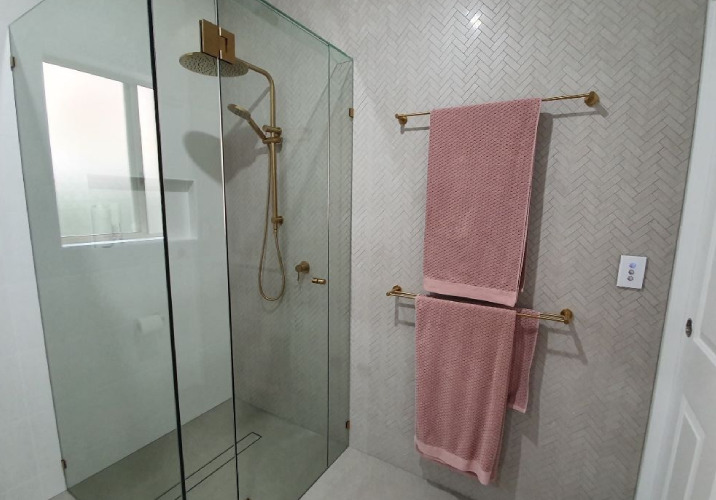 Two pink towels on a towel rack in a white bathroom 