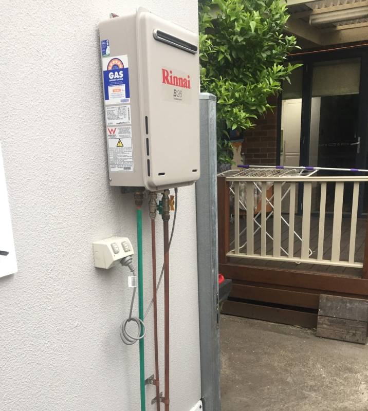 A gas pump outside on the exterior wall of a home
