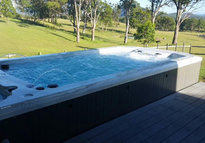 An above ground plunge pool with jets on a deck 