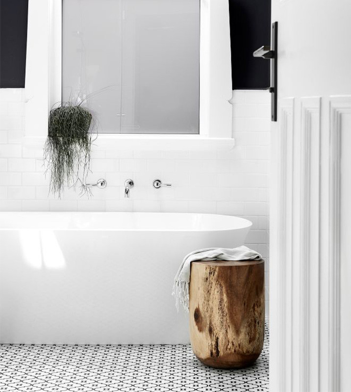 Stylish modern white bathroom with bathtub and indoor plant on windowsill