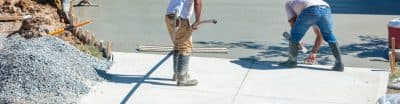 Men working on resurfacing a concrete driveway