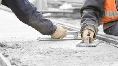 construction workers leveling concrete pavement