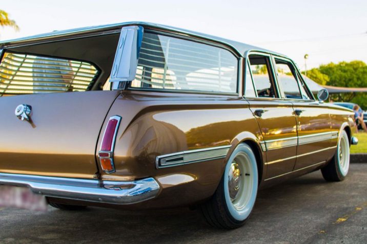 Vintage brown station wagon with white wall tyres and venetians in the back.
