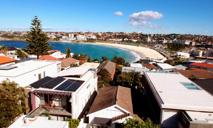 An aerial shot of house roofs in bondi with the beach in the background. 