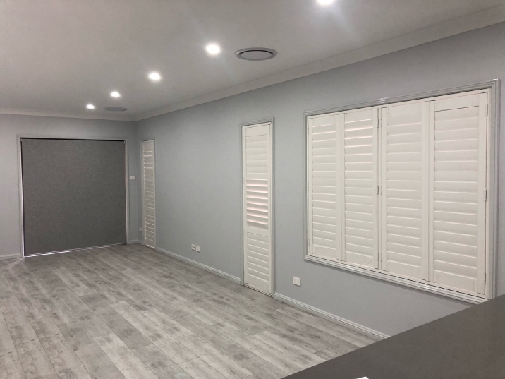 Three sets of white shutters on a light blue wall in a home. 