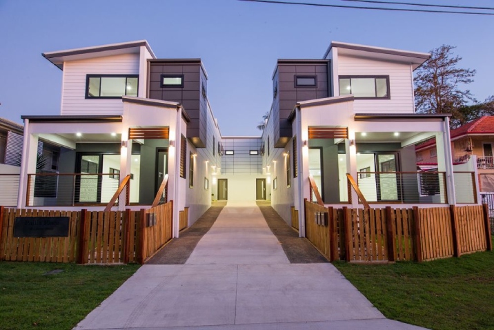 A modern duplex with a driveway splitting each residence. 