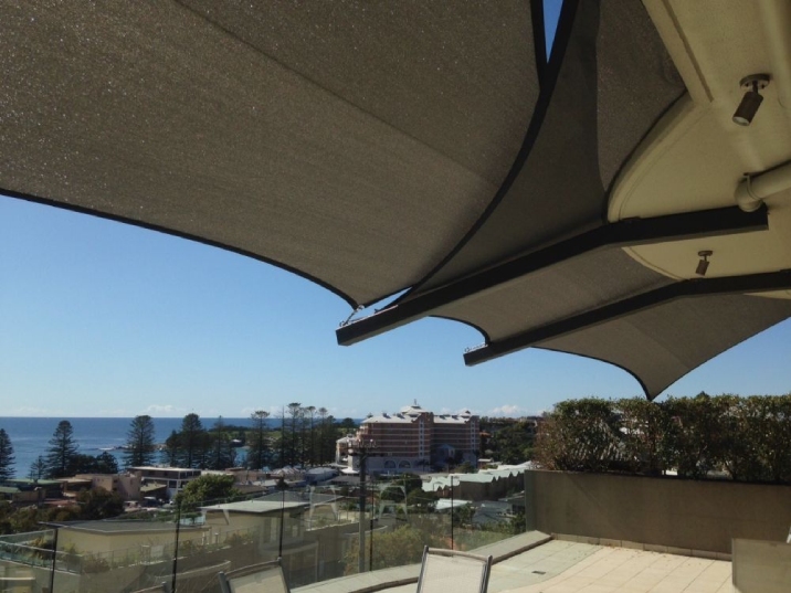Shade sail on the balcony of an apartment with a view of the ocean.