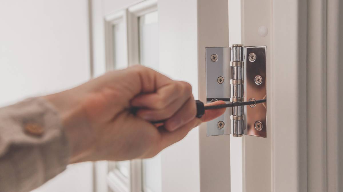a man using a screwdriver to install the door