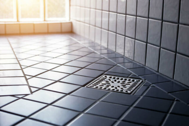 Shower Hob vs Hobless Shower - Tiled hobless shower floor with center drain and sloped surface