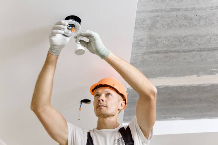 An electrician installing an LED downlight
