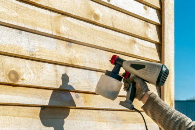 Australian framing standards - Applying an anti-termite and pest control coating to a wooden house exterior.