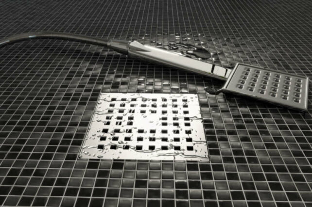 Shower Hob vs Hobless Shower - Dark mosaic tile hobless shower with modern drainage design