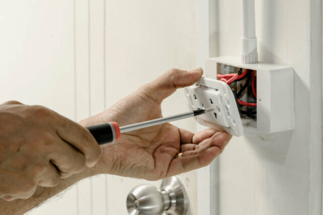 Phone socket wiring Australia - Technician installing a wall plate with phone and power sockets