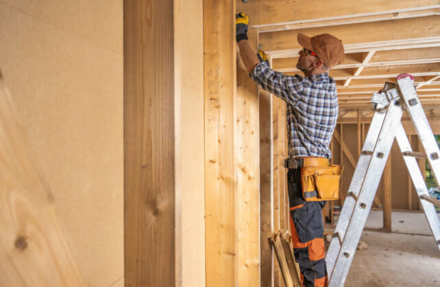 Australian framing standards - Carpenter assembling interior wall framing with precision.